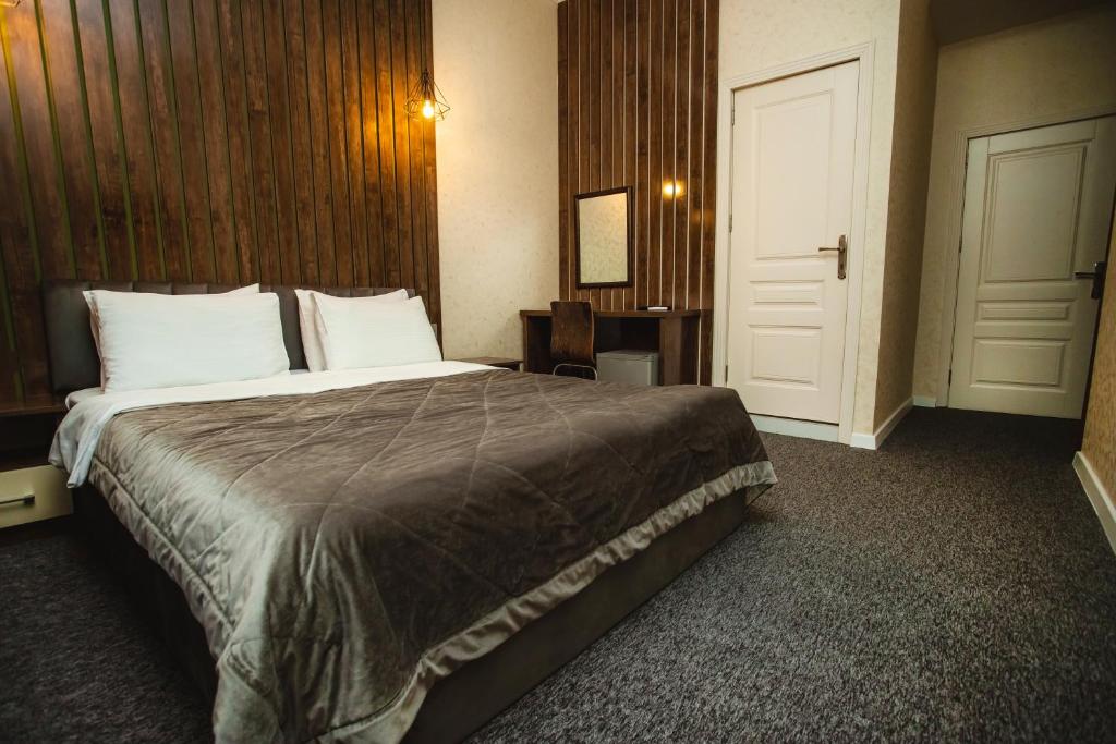 巴库Moss Art Boutique Hotel的一间酒店客房,设有一张大床和一扇门