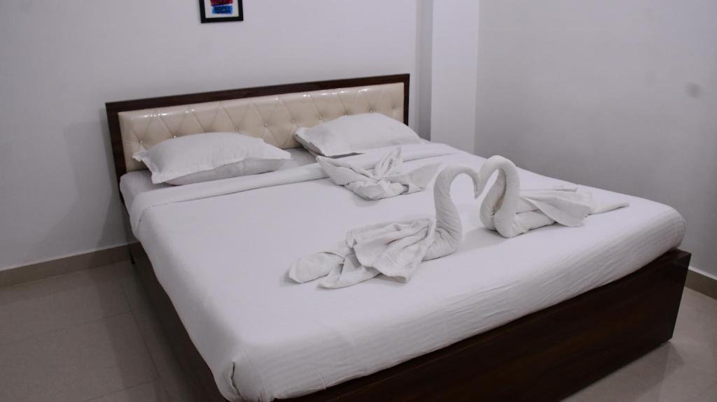 德奥加尔Rivasa homes的一张带白色床单和毛巾的床