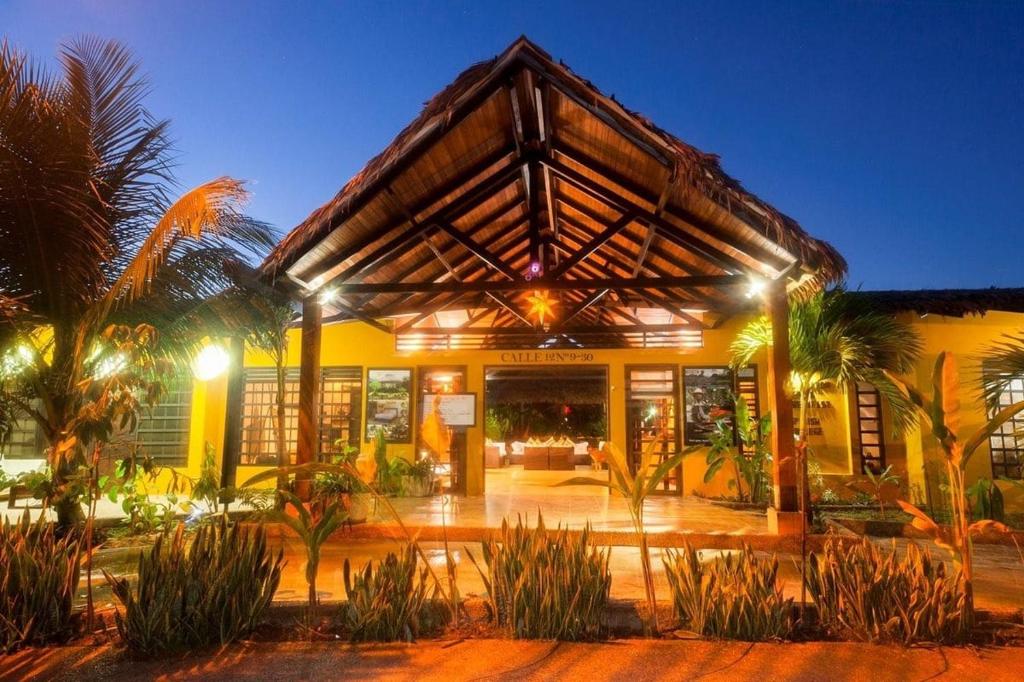 莱蒂西亚亚马逊住宿加早餐酒店的一座棕榈树的黄色建筑