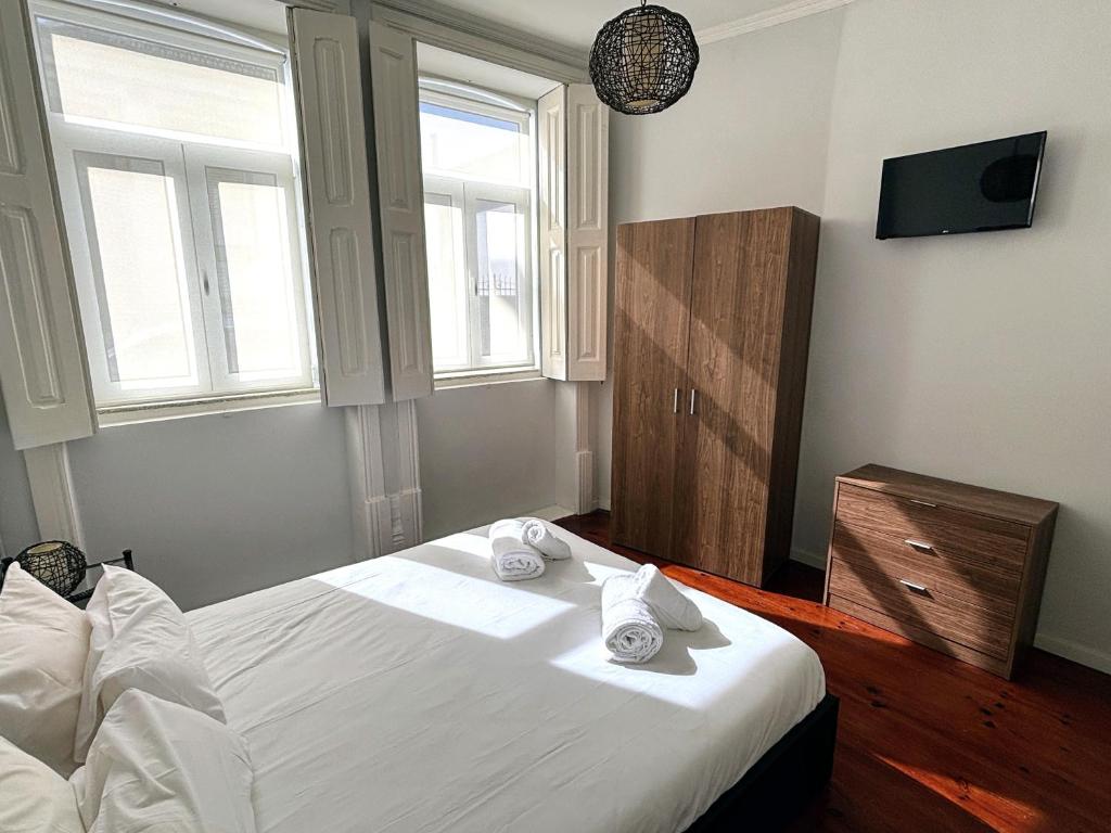 波尔图Covelo Apartment的卧室配有白色床和毛巾