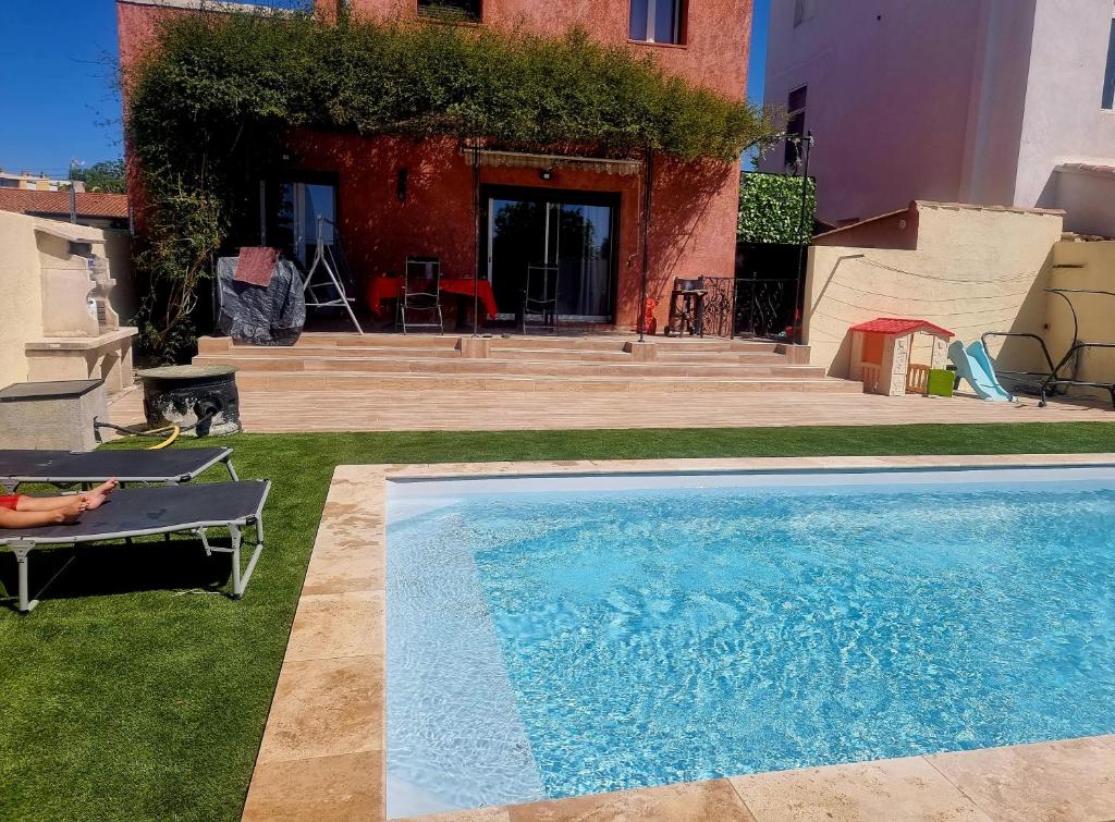 罗尼亚克Agréable Villa 8pers avec vue mer LOGEMENT ENTIER的坐在游泳池旁椅子上的人