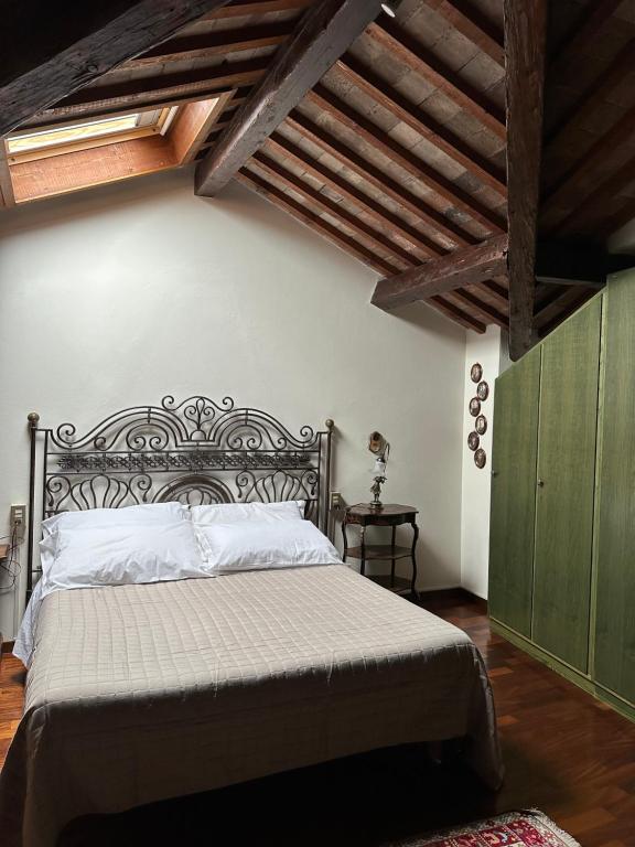 巴萨诺－德尔格拉帕Residenza Angela的一间带一张大床的卧室,位于一个拥有木制天花板的房间