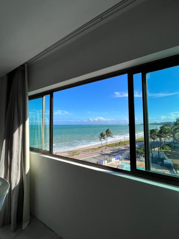 马塞约Suíte 511, do Hotel Ritz Suítes的客房设有窗户,享有海滩美景。