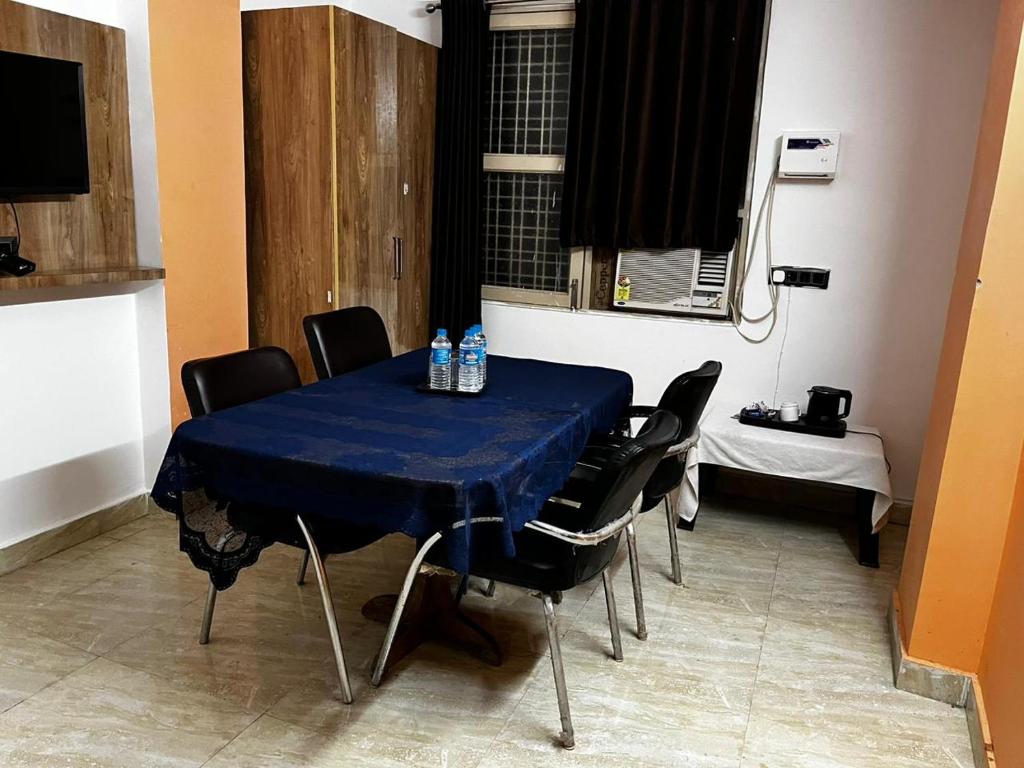 新德里wide Hotel的一张桌子,上面有椅子和蓝桌布