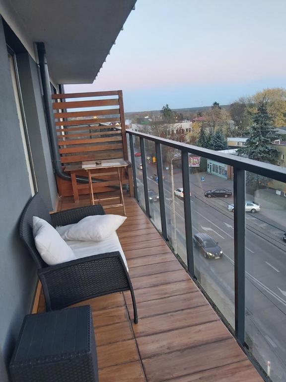 维什库夫Przy Parku的阳台配有两把椅子和一张桌子,街道上