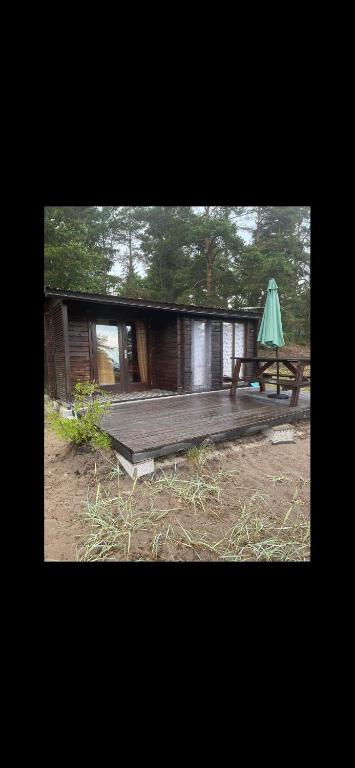 KataseДомик на берегу Чудского озера的小屋配有野餐桌和雨伞