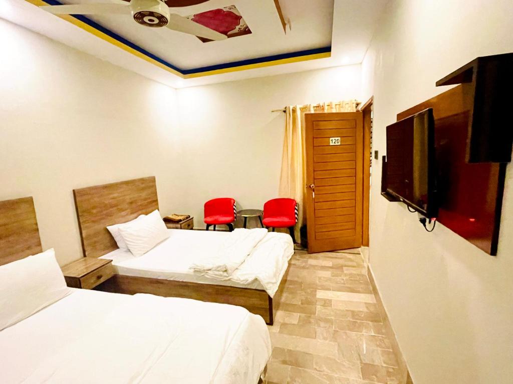 卡拉奇Hotel Highway Link的酒店客房,设有两张床和两张红色椅子