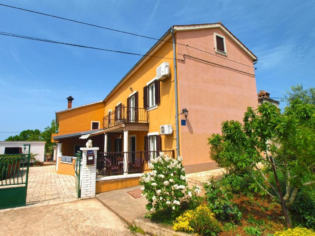 瓦图拉Ferienwohnung für 6 Personen ca 75 qm in Valtura, Istrien Südküste von Istrien的黄色和橙色的房子设有阳台