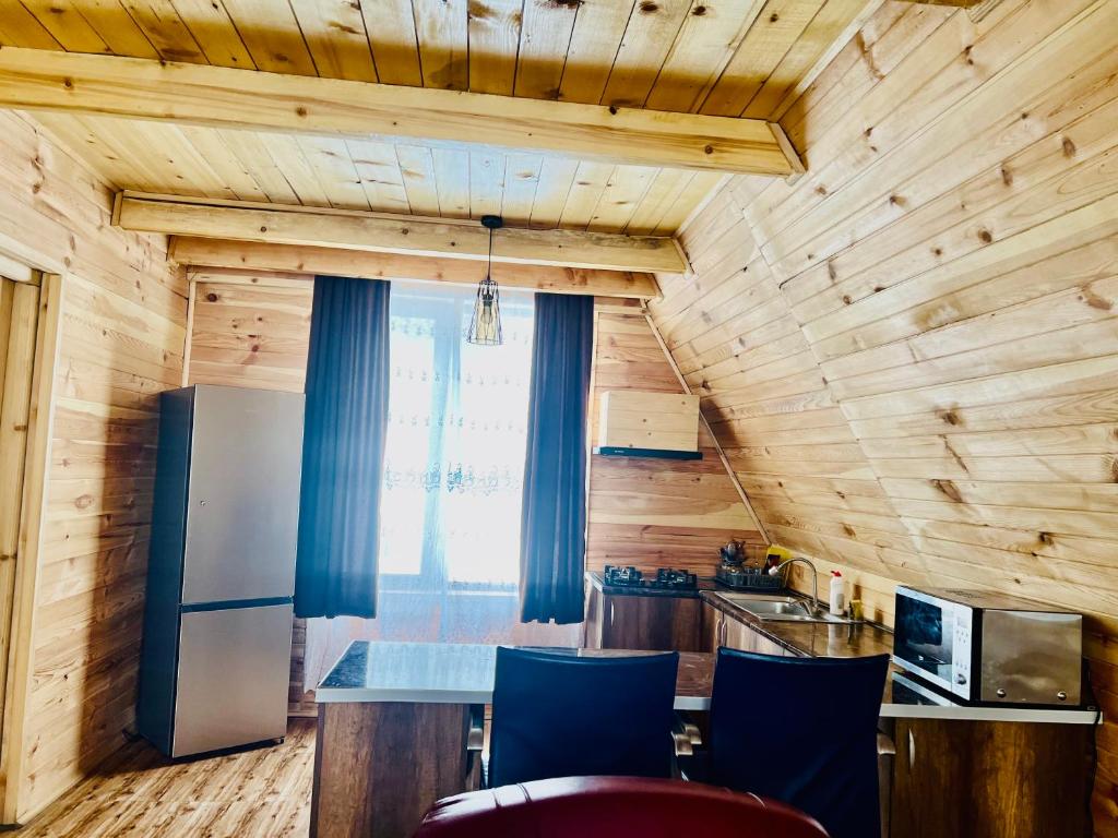 博尔若米Borjomi-sadgeri''Twins''的厨房设有木墙和一张带蓝色椅子的桌子。