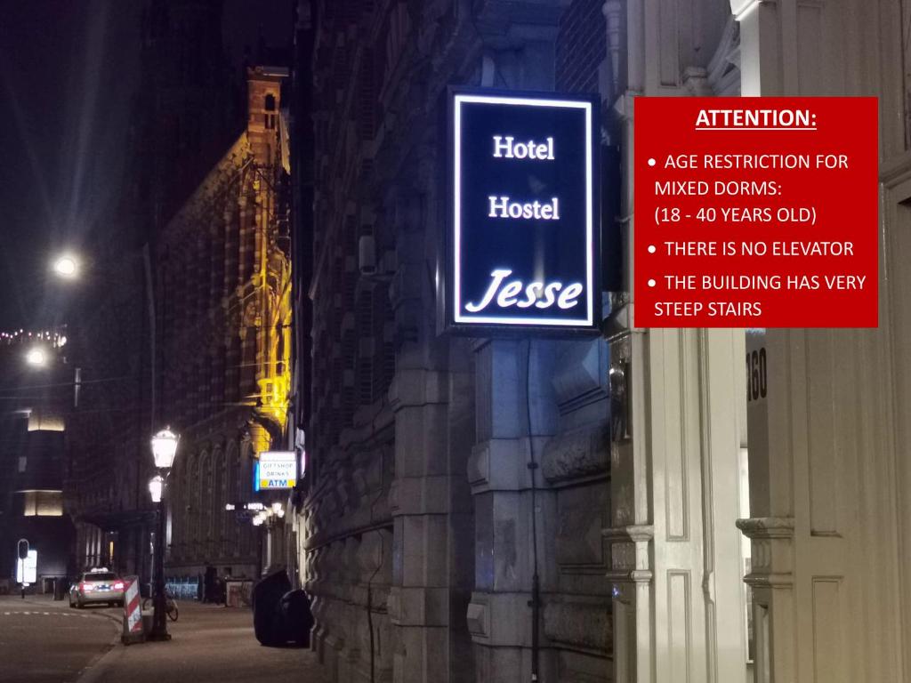 阿姆斯特丹Hotel Jesse的夜间建筑物一侧的标志