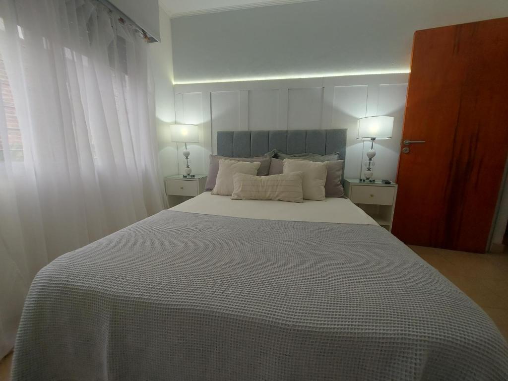 GualeguaychúCasa con piscina de uso exclusivo的一间卧室配有一张大床和两盏灯