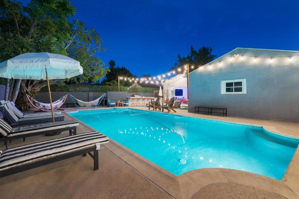 洛杉矶Angel&Rose Universal Hollywood Heated Pool House King Bed的一个带两把椅子和遮阳伞的游泳池