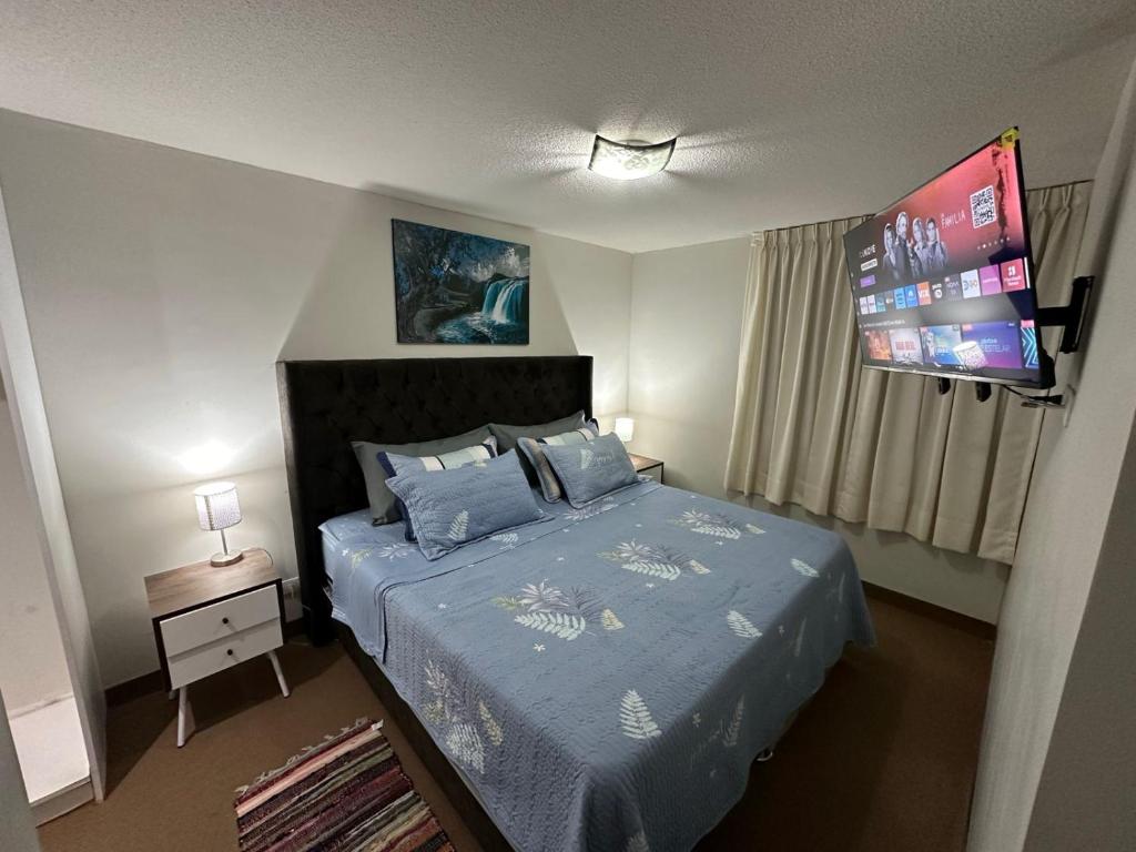 利马595 Departamento en Chorrillos的一间卧室配有一张带蓝色棉被的床