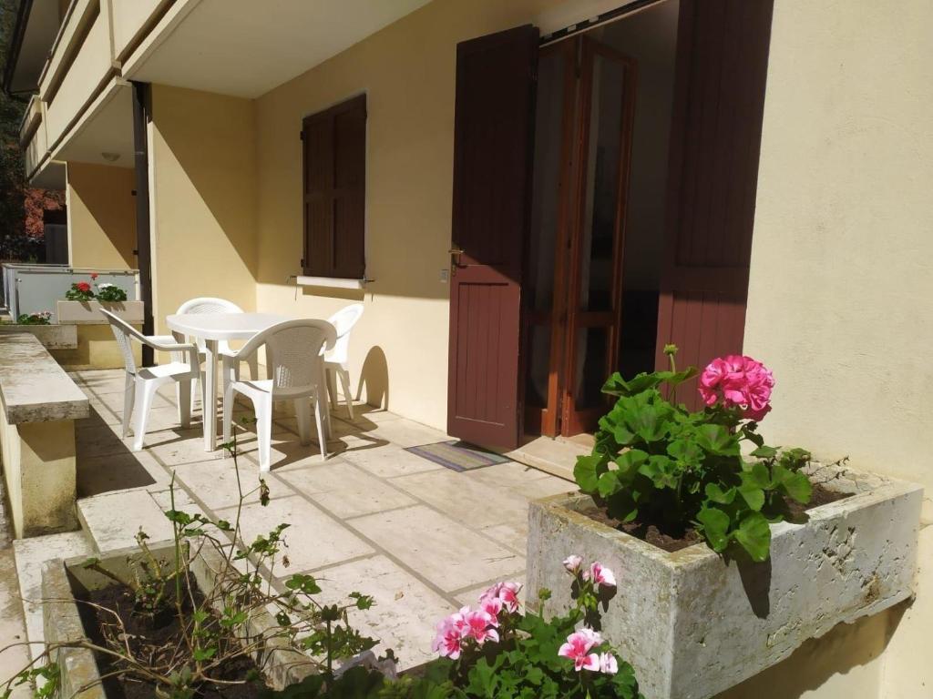 罗索利纳Ferienwohnung für 4 Personen ca 50 qm in Rosolina Mare, Adriaküste Italien Venedig und Umgebung的庭院配有桌椅和鲜花