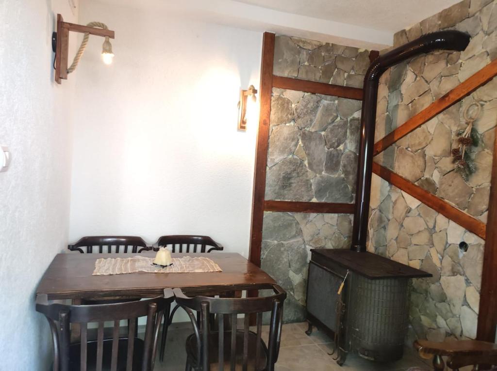 斯科普里Vila Fantastico的一间设有桌椅和石墙的用餐室