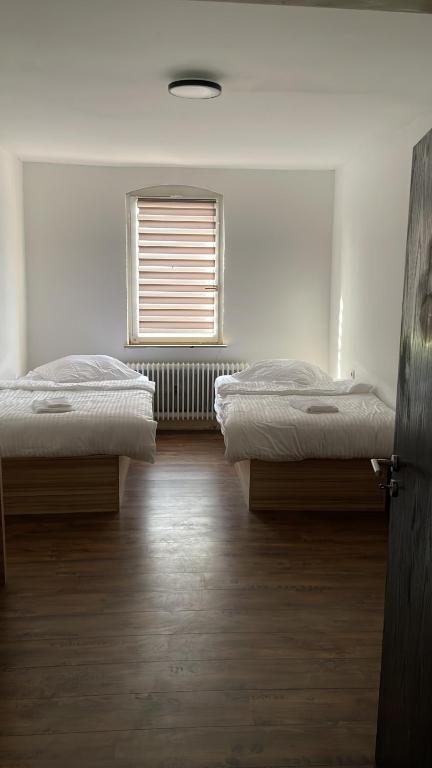 图特林根Tacidur Home的带窗户的客房内的两张床