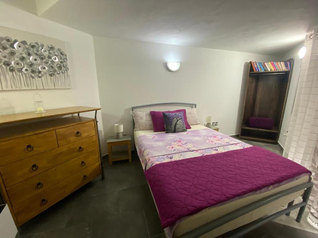 比尔古Birgu Studio Maisonette的一间卧室配有紫色的床和梳妆台