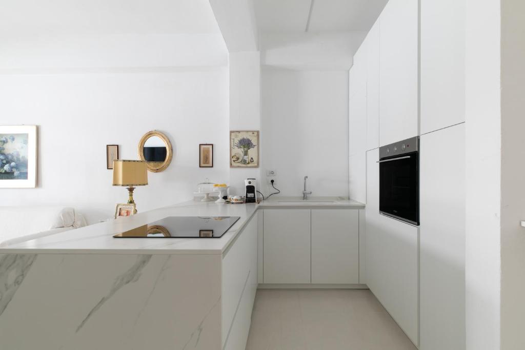 卡托利卡Suite vista mare的白色的厨房配有水槽和微波炉