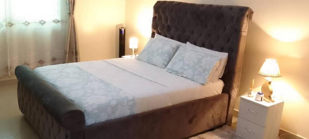 坎帕拉CATHYCATHIE的一间卧室配有一张大床和大床头板