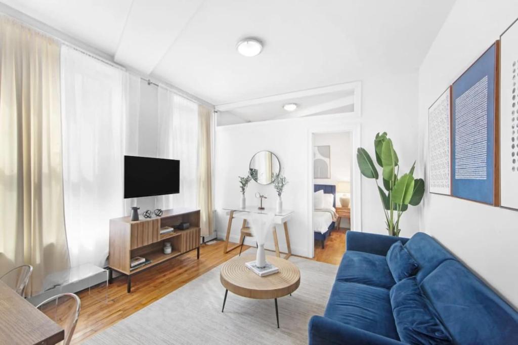 纽约139-2E west village 1BR best value的客厅配有蓝色的沙发和电视