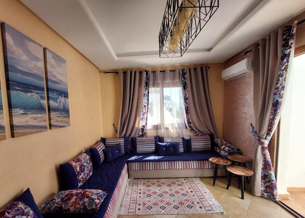 卡博尼格洛Lilacs Garden Cabo Negro Piscines WiFi -only family的客厅设有蓝色的沙发和窗户。