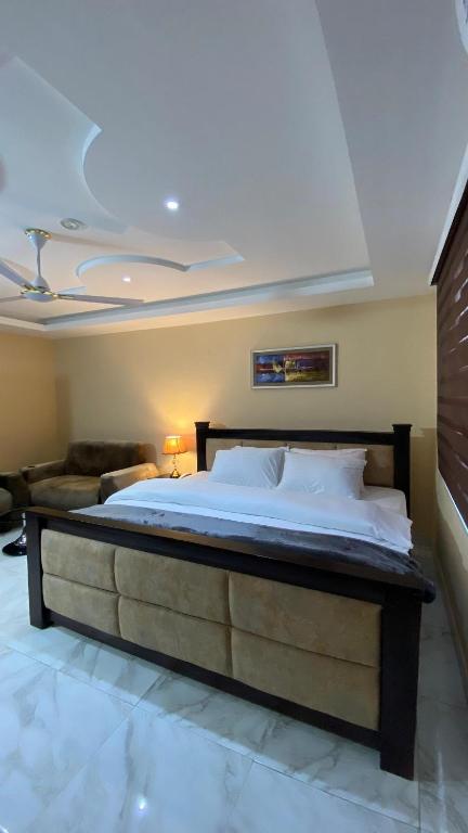 阿克拉Century Premier Suite的一间卧室配有一张大床和一张沙发