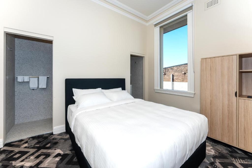 悉尼Tempe Hotel Sydney的卧室设有一张白色大床和一扇窗户。
