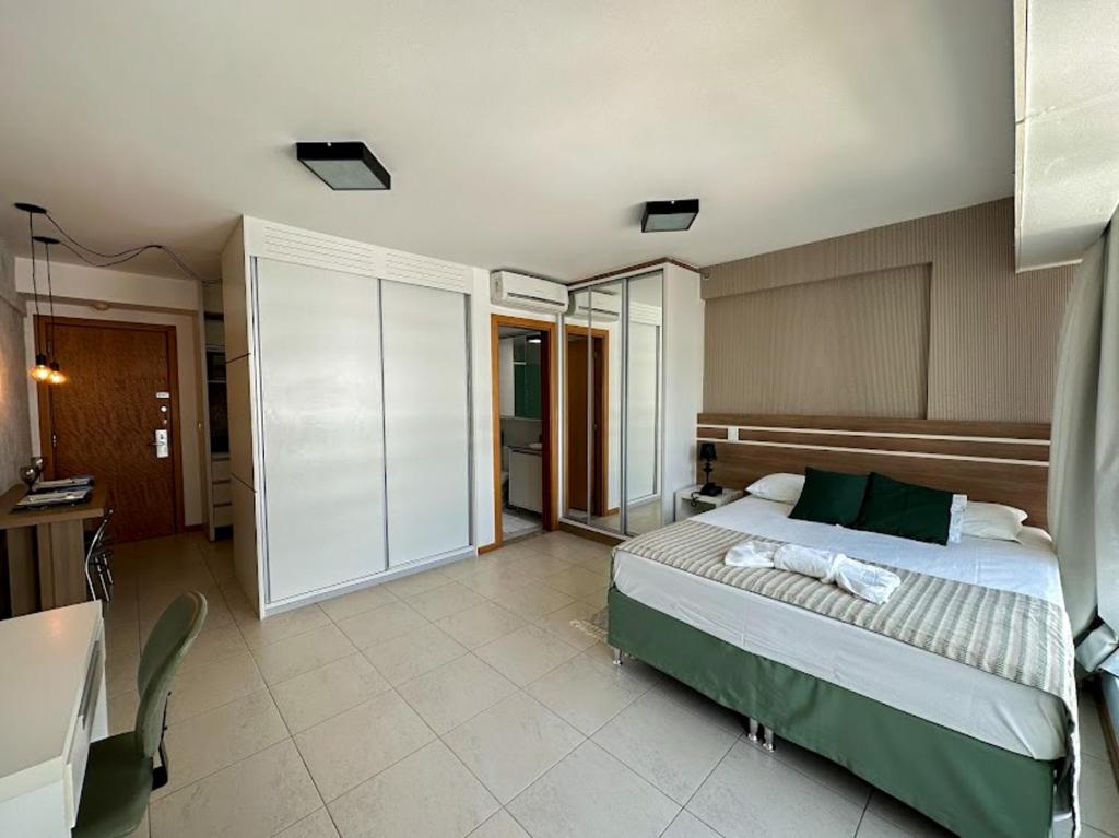 巴西利亚Flat Saint Moritz Brasília Hotel的一间卧室配有一张床和一张书桌