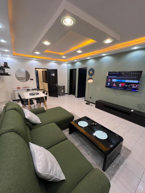 达喀尔Le cocon by sdm的客厅配有绿色沙发和平面电视