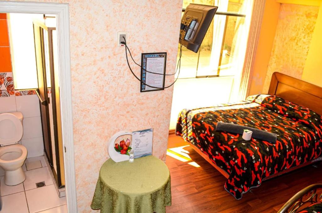拉巴斯Hotel Lizarraga的小房间设有床、桌子和卫生间