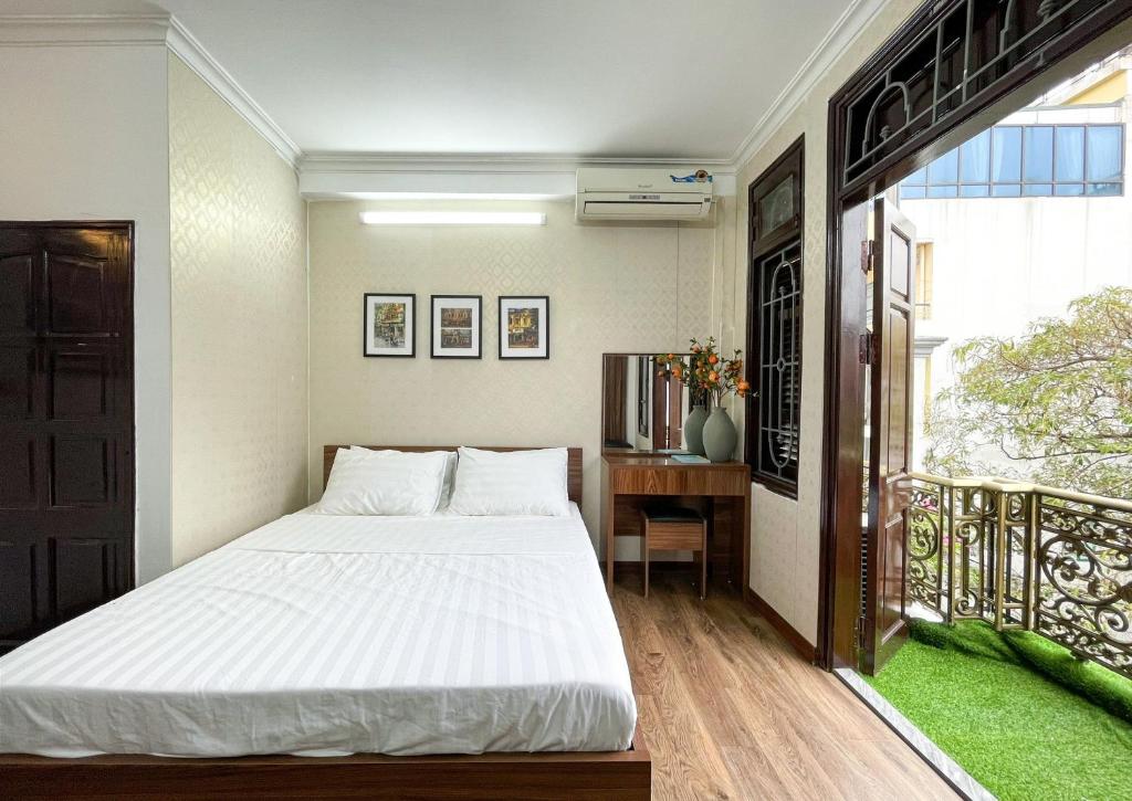 河内Hanoi Oriental Viewl Hotel的一间带白色床的卧室和一个阳台