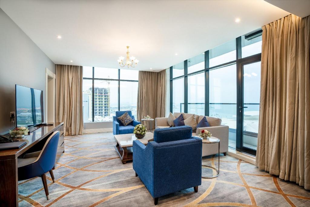 多哈فندق شراعوه الملكي - Luxury的客厅设有蓝色家具和大窗户
