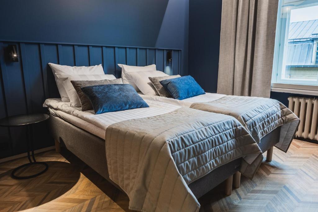 图尔库Ineon Hotel的一间卧室配有两张带蓝色枕头的床