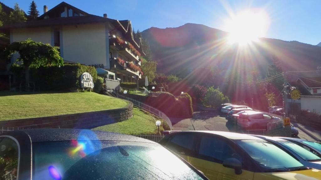 蓬泰迪莱尼奥Hotel Garni Sorriso的一群在街上停车的汽车,阳光照耀着