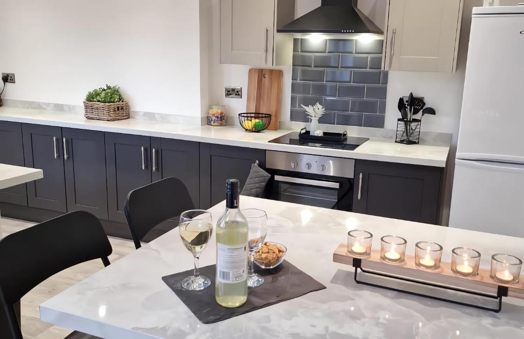 唐克斯特Ferrers House的厨房配有桌子、一瓶葡萄酒和玻璃杯