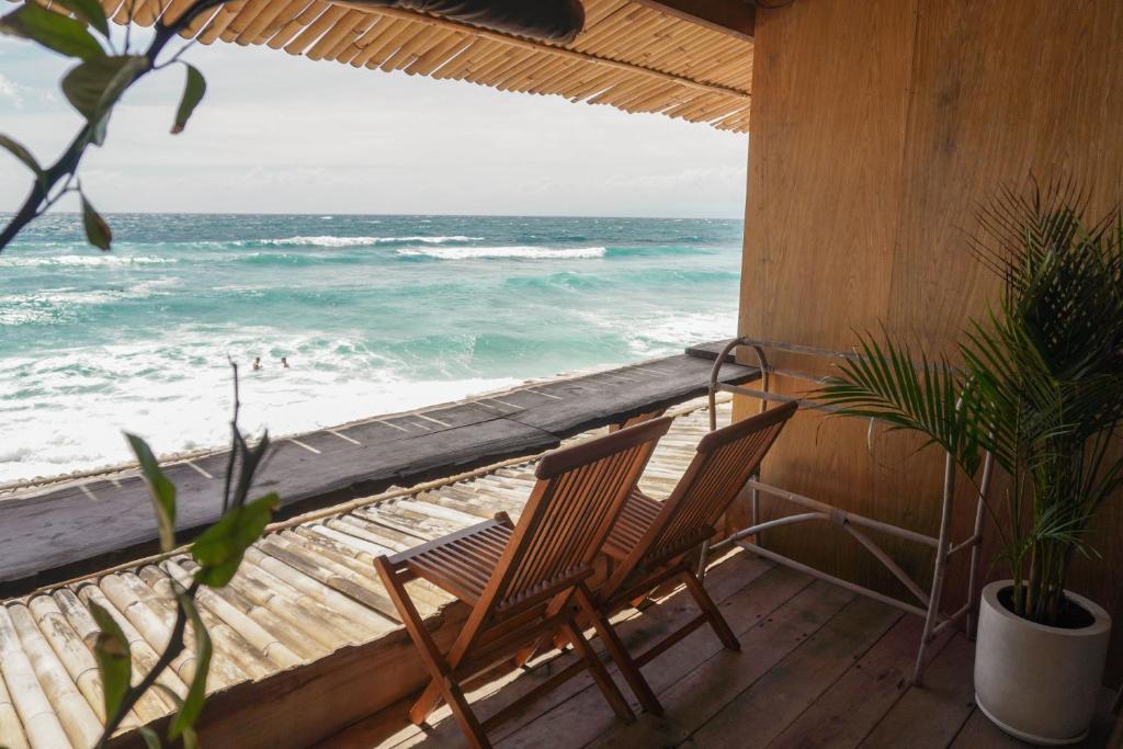 乌鲁瓦图Beachfront - The Surf Lodge的阳台上的两把椅子,俯瞰着大海