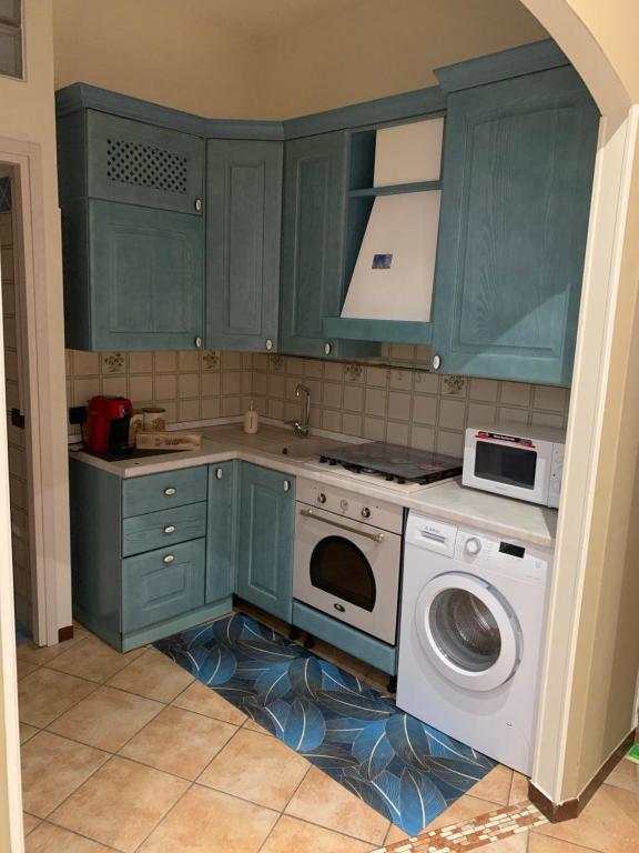 拉文纳Stefy House的厨房配有绿色橱柜和洗衣机。