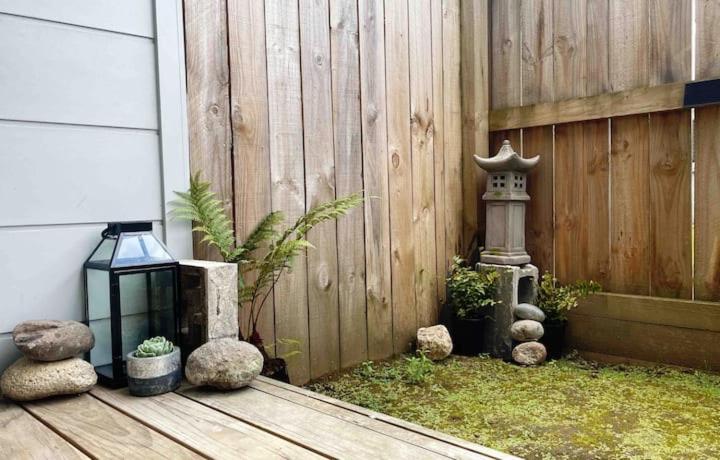 汉密尔顿Waikato Uni guest room with private bathroom的一个带灯笼和木栅栏的花园