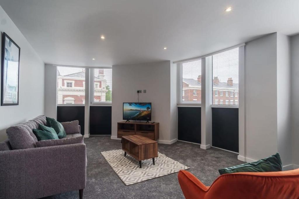 利物浦Modern 2 Bedroom Apartment in Liverpool的带沙发和电视的客厅以及部分窗户。