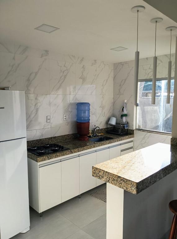 古里里Casa Luxo e Sossego 50m da Praia的厨房配有白色橱柜和台面