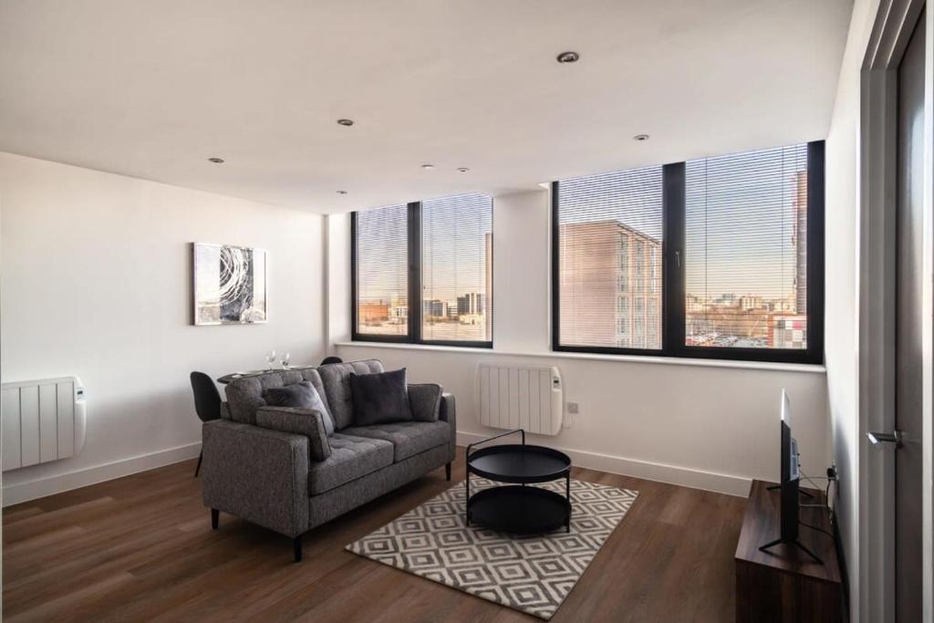 曼彻斯特Modern & Spacious 1 Bed Apartment - Old Trafford的带沙发的客厅和部分窗户。