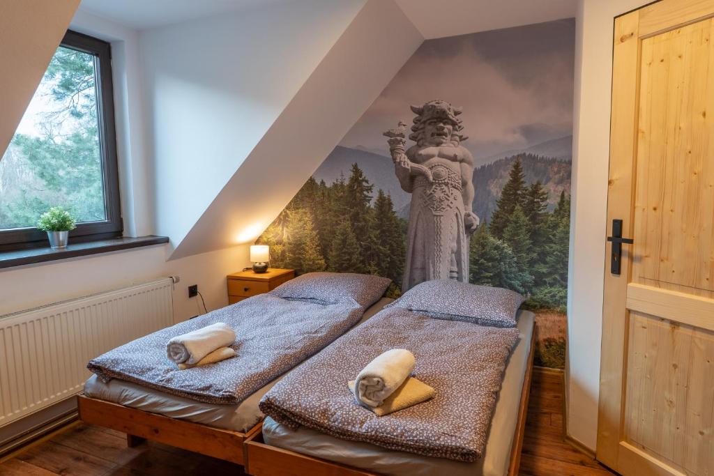 Dolní BečvaKoliba Pod Horů的墙上壁画的房间里设有两张床