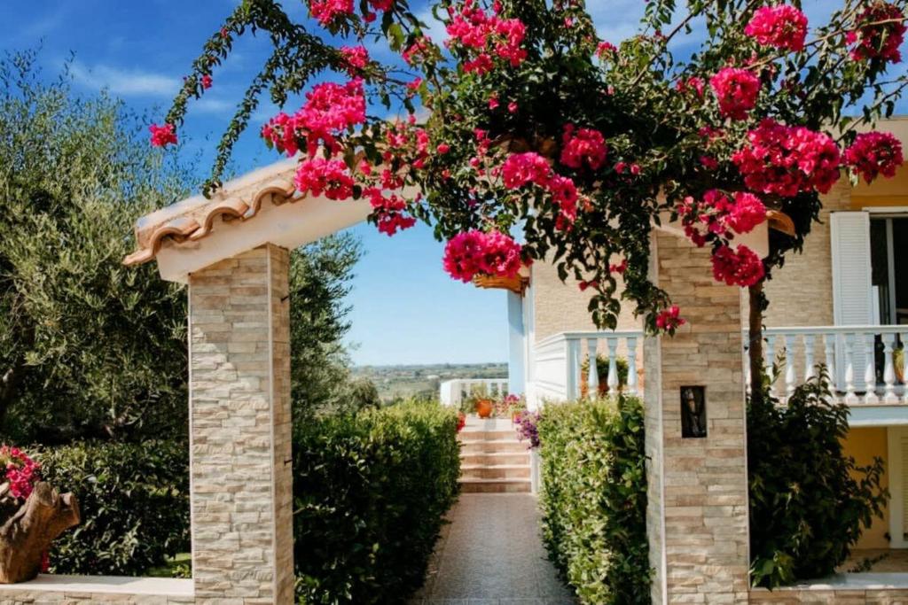 斯卡费迪亚Skafidia Seaview Retreat - Orpheas Seaview Home的通往粉红色花房的拱门