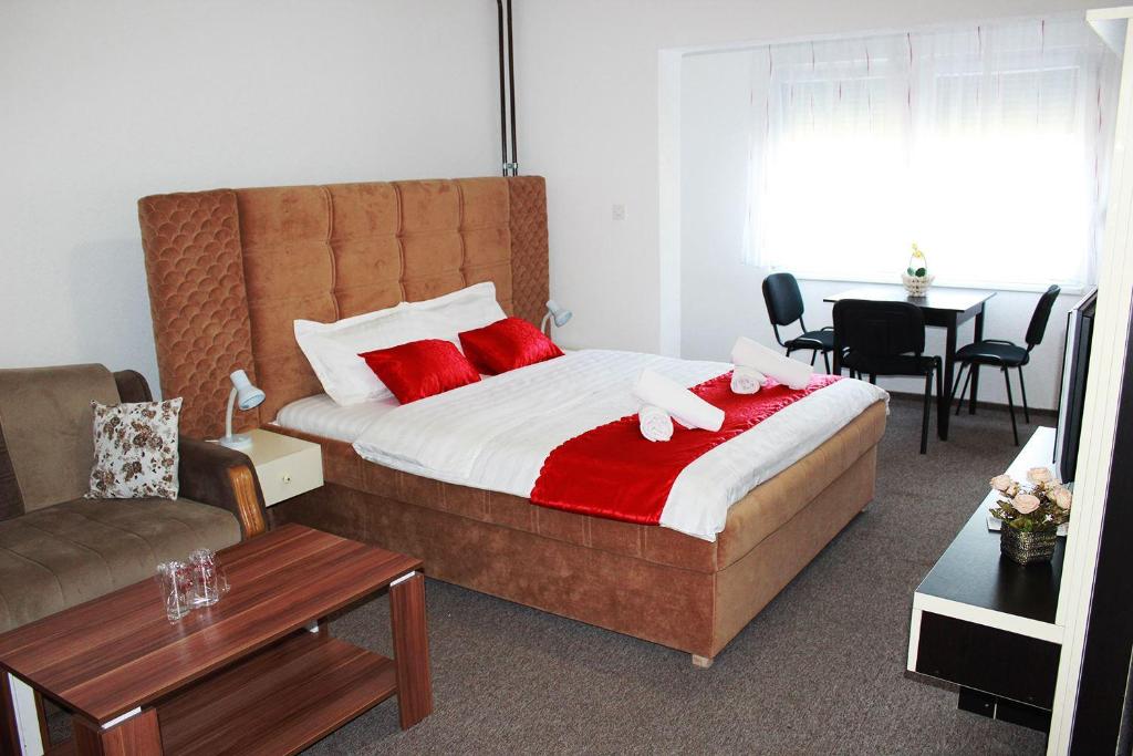 泽尼察Hostel Imran Zenica的一间卧室配有一张床,上面有两条粉红色的毛巾