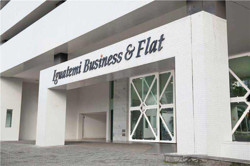 萨尔瓦多Apto Hotel Iguatemi Business Flat Corporation的白色砖砌建筑,上面有标志