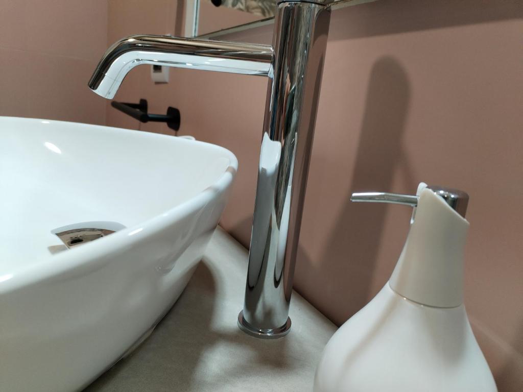夸尔图-圣埃莱娜Antico Centro Quartu B&B的一间带水槽和白色花瓶的浴室