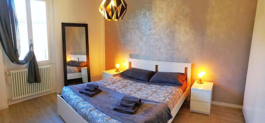 博洛尼亚Bologna Holiday House的一间卧室配有一张带两盏灯和镜子的床