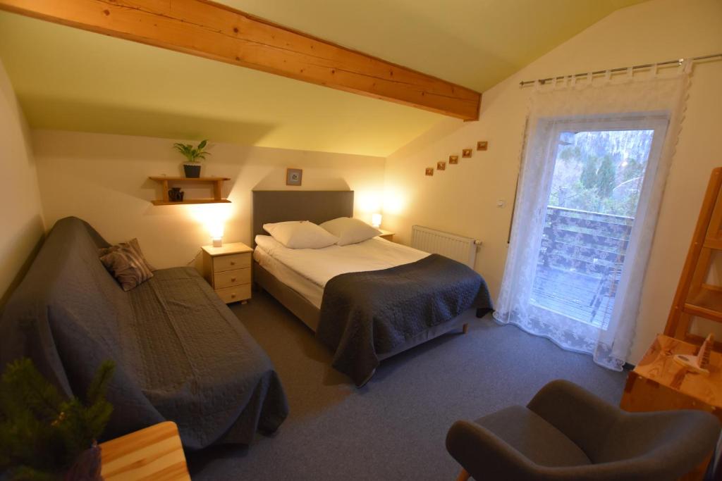什切尔克Apartamenty Czyrna przy Gondoli的卧室配有床、椅子和窗户。