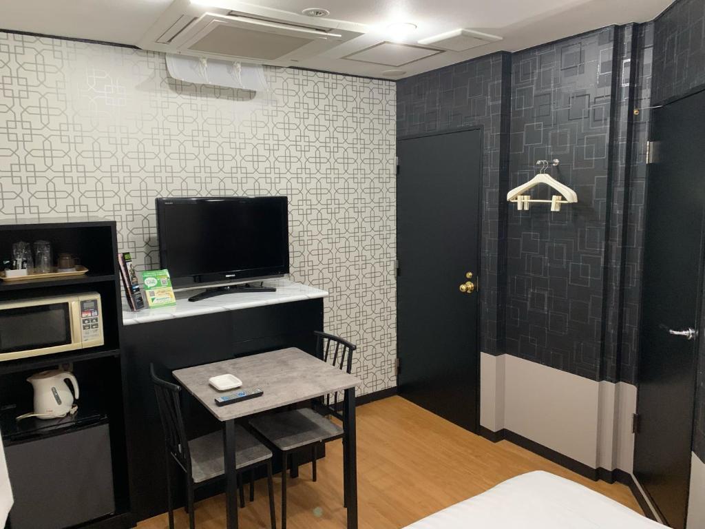 仙台ホテル　るテラスⅡ的一间设有小桌子和电视的房间