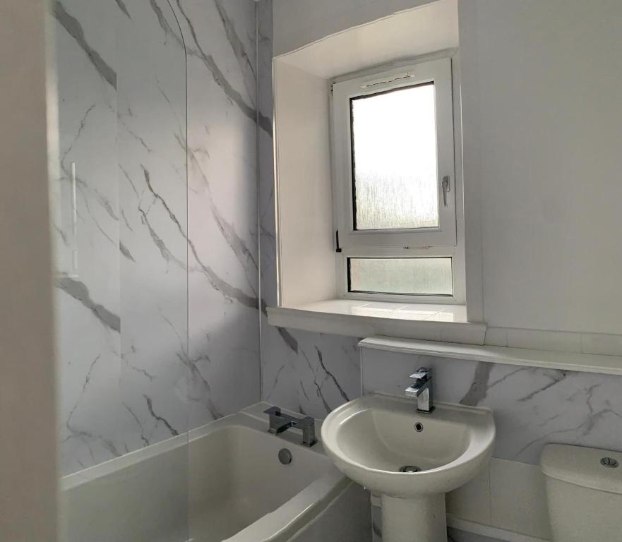阿伯丁Beautiful 2-Bed Apartment in Aberdeen的一间带水槽和卫生间的浴室以及窗户。